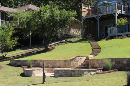 Curved retaining wall with terraced plantings in calhoun ga backyard